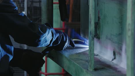 Close-up-of-a-worker-welding-machinery-in-an-industrial-workshop-in-slow-motion