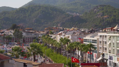 The-tourists-are-enjoying-a-coastal-view-of-Marmaris-restaurants-and-bars-with-a-backdrop-to-mountains-and-flats