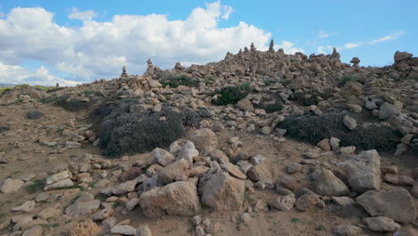 A-rugged-landscape-with-rock-piles-at-the-Tombs-of-the-Kings-in-Pafos,-Cyprus,-under-a-blue-sky