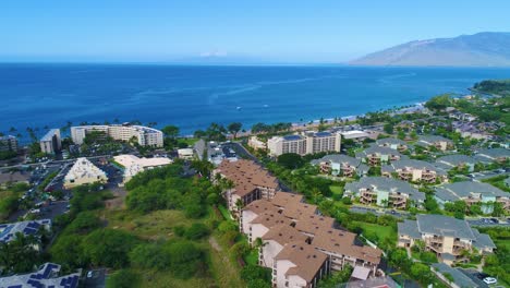 Flying-low-next-to-a-complex-of-residential-buildings-on-Kihei,-Hawaii-on-a-sunny-day,-pedestal-up