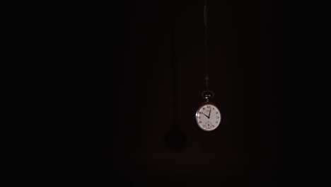 Reloj-De-Bolsillo-Se-Balancea-Sobre-Un-Fondo-Oscuro