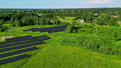 Green-fields,-rural-village-and-solar-panel-farm,-aerial-drone-view