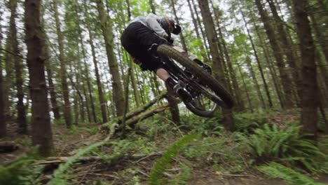 Experienced-downhill-mountainbiker-performing-classic-whip-on-dirt-feature,-slow