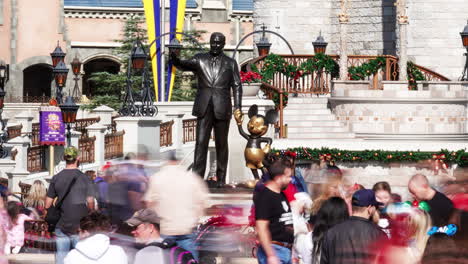 Time-lapse-of-a-Disney's-Magic-Kingdom-park-goers-taking-in-the-Partner's-statue-featuring-Walt-Disney-and-Mickey-Mouse-in-front-of-Cinderella's-castle