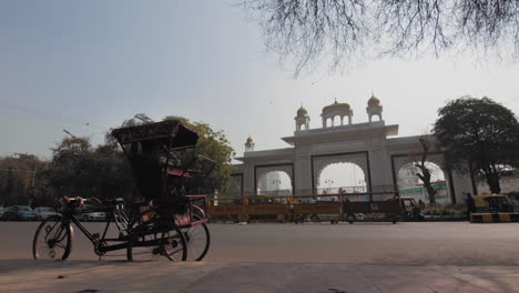 Gurudwara-Temple-in-New-Delhi,-with-a-rikshawala-waiting-for-passengers