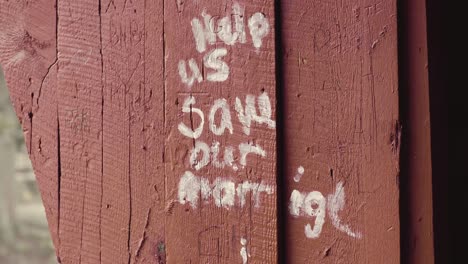 Graffiti-Auf-Einer-Roten-überdachten-Brücke-Mit-Der-Herzlichen-Aufschrift-„Helfen-Sie-Uns,-Unsere-Ehe-Zu-Retten“