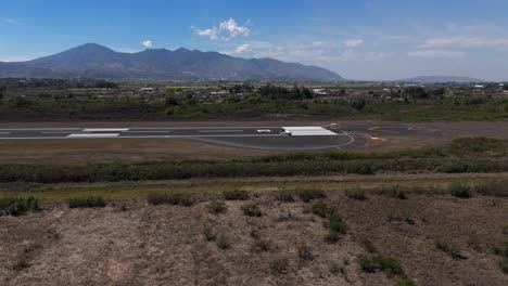 Mexikanisches-Kleines-Flugzeug,-Das-An-Einem-Sonnigen-Tag-Mit-Berghintergrund-Mit-Einer-Drohne-Abhebt