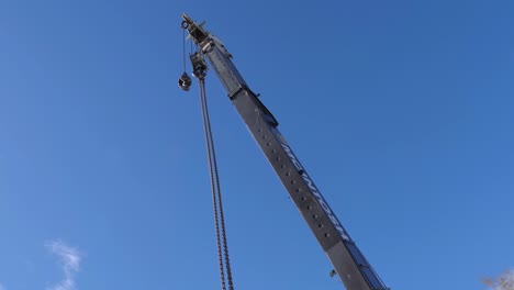 A-large-mobile-crane-swings-the-boom-around-looking-directly-up-at-the-head