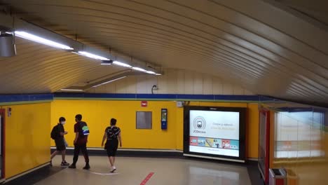 Bajando-Por-Escaleras-Mecánicas-En-El-Metro-De-Madrid-Detrás-De-Los-Viajeros,-Cámara-Lenta