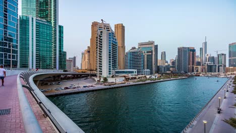 A-timelapse-video-of-Dubai-Marina-during-sunset,-with-boats-and-yachts-moving-in-the-area