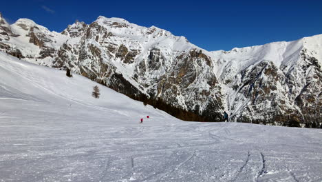 Ein-Skifahrer-Fährt-Eine-Skipiste-Hinunter,-Mit-Einer-Wunderschönen-Bergkulisse-Im-Hintergrund