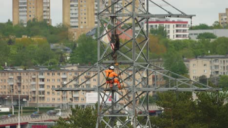 Ein-Kletterer-Arbeiter-Auf-Einem-Hochspannungsmast-In-Der-Stadt