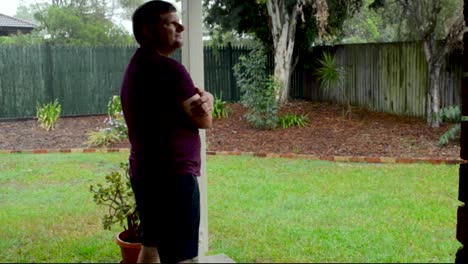 Man-looks-out-at-Rain-on-a-Stormy-Day-in-Brisbane