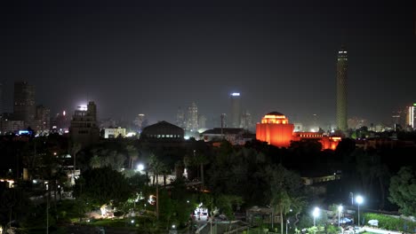 A-mosque-at-nighttime-glowing-with-red-lights-in-Cairo,-Egypt-as-seen-from-a-hotel-balcony