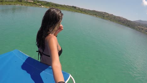 Pretty-woman-taking-a-selfie-on-the-boat-in-Greece-at-the-lake-in-middle-of-Crete-island