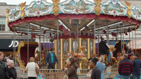 medium-shot-of-people-riding-the-carousel-at-a-xmas-market