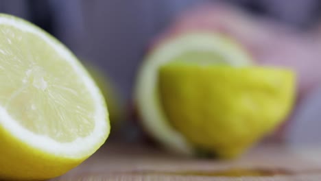 Lemon-being-chopped-in-half,-halved-lemon-sitting-in-foreground