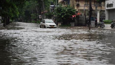 Car-slowly-moving-through-water-logged-streets-of-Kolkata,West-Bengal,-India