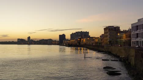 Beautiful-Time-Lapse-view-of-the-Old-Havana-City,-Capital-of-Cuba,-by-the-Ocean-Coast-during-a-vibrant-sunny-and-colorful-sunrise