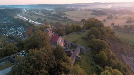 Arruina-Isenburg-Con-Un-Vibrante-Amanecer-Sobre-El-Brumoso-Río-Ruhr,-órbita-Aérea-De-Drones