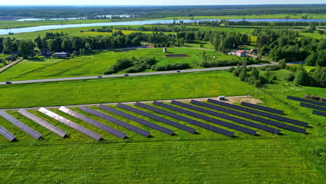Sun-reflecting-off-solar-panels-in-countryside-farm,-aerial-orbit-view