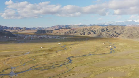 Mongolian-ger-tents-with-Bayan-Olgii-city-background,-Altai-Mountains,-aerial-view