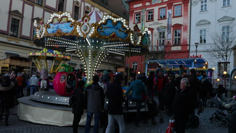 Flowing-crowds-of-people-during-Christmas-market-square-near-children's-attraction-chain-carousel-at-Zeleny-Square-markets-captured-at-4k-60fps-slow-motion