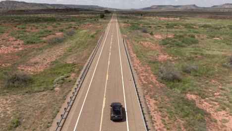 Una-Toma-Aérea-De-Un-Automóvil-Conduciendo-Por-Una-Carretera-En-Nuevo-México,-EE.UU.