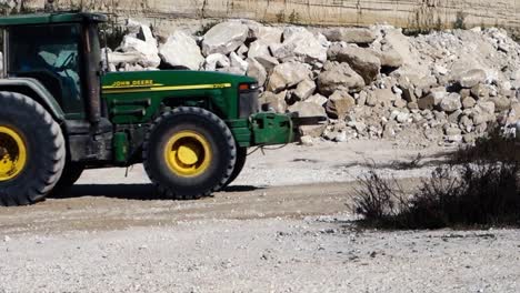 John-Deere-Traktor-Schleppt-Erdbewegungsmaschinen-Auf-Einer-Baustelle-In-Spanien