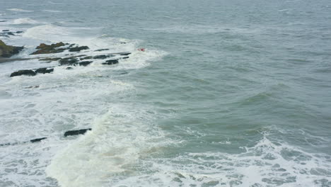 Luftbild-Von-Wellen,-Die-Während-Eines-Sturms-Gegen-Felsen-Entlang-Der-Küste-Schlagen