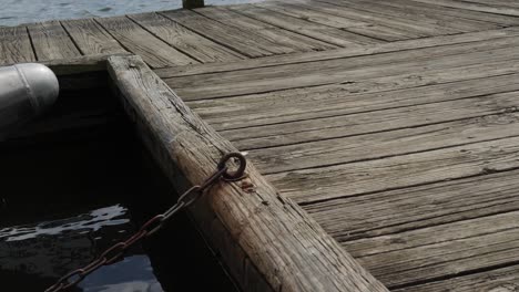 wooden-boat-dock-on-lake-with-pontoon-boat-chained-tied-off