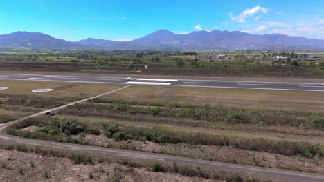 Aerial-shot-of-an-plane-takeoff-in-Mexico-Nayarit,-airfields,-and-mountains-backgrounds