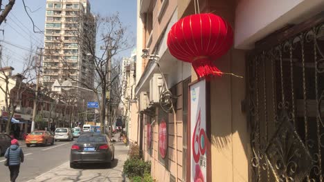 Sunny-daylight-on-a-two-story-townhouse-in-South-Shanxi-Road-with-modern-high-rise-buildings-in-the-background-as-a-typical-mix-of-the-two-worlds-in-French-Concession,-Shanghai