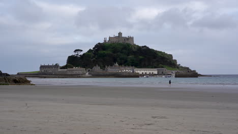 Solitary-person-running-on-the-beach-toward-the-sea-of-Marazion-in-Cornwall-right-in-front-of-Mount-St-Michael
