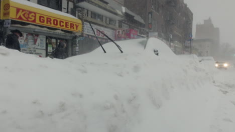 Car-buried-in-the-snow-with-the-windshield-wipers-up-during-a-snowstorm-in-Brooklyn,-NY