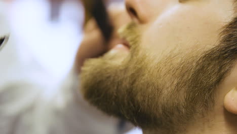 Man-getting-beard-trimmed,-close-up