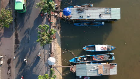 Drone-shot-looking-down-over-canal-edge-with-boats-tied-up-to-the-shore