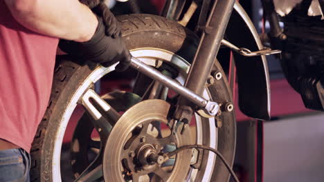 Close-Up-of-Hands-Using-Wrench-to-Loosen-Bolt-During-Motorcycle-Teardown
