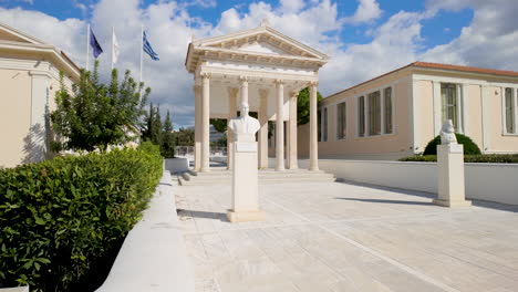 Neoclassical-building-in-Pafos,-Cyprus,-emphasizing-its-columns-and-surrounding-greenery