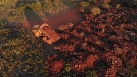 Aerial-View-of-a-Dump-Truck-Dumping-a-Load-in-a-Field-During-Sunset