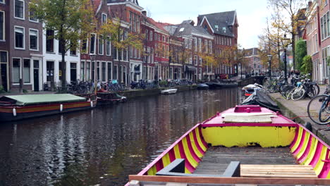 Blick-Auf-Flusskanäle-Während-Eines-Wunderschönen-Herbsttages-Mit-Verankerten-Holzbooten-In-Leiden,-Niederlande