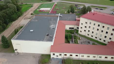 Niedrige-Kreisförmige-Luftaufnahme-Des-Dachs-Einer-Grundschule