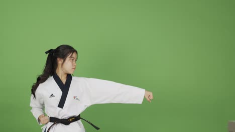 Junge-Asiatische-Frau-Ist-Eine-Erfahrene-Kampfsportlerin---Zeitlupe-Mit-Grünem-Hintergrund