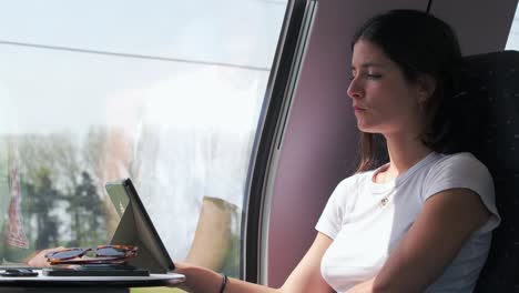 Frau-Arbeitet-Während-Der-Zugfahrt-Am-Tablet,-Konzentriert-Und-Entspannt