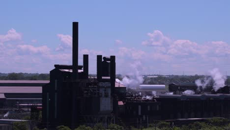 Factories-producing-pollution-in-the-air-on-a-sunny-day-with-blue-skies