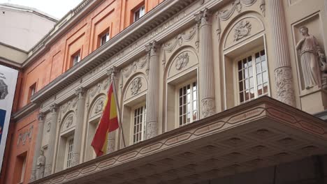Statische-Aufnahme-Der-Spanischen-Flagge,-Die-Vor-Dem-Teatro-De-La-Zarzuela-In-Madrid,-Spanien-Weht