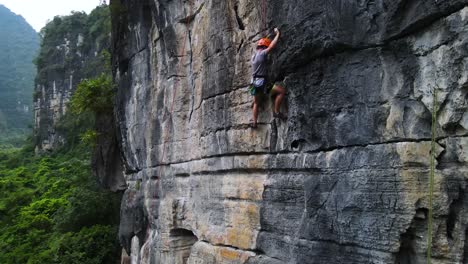 Strong-Athlete-Rock-Climbing-Karst-Limestone-Mountain-in-Yangshuo,-China