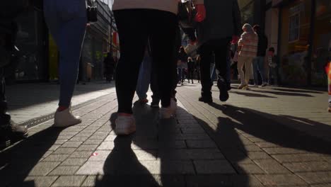 Slow-motion-handheld-shot-of-crowd-of-people-walking-and-crossing-in-the-busy-street-of-Cologne-city-on-a-warm-sunny-day,-Western-Germany