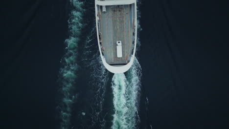 Top-down-shot-overhead-a-ferry-travelling-with-cargo-onboard-creating-waves