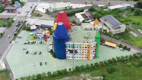 Aerial-high-angle-shot-capturing-touristic-attraction-colorful-lucky-art-crayon-factory,-DIY-experience-center-for-children-and-family-and-townscape-at-Yilan-County,-Taiwan